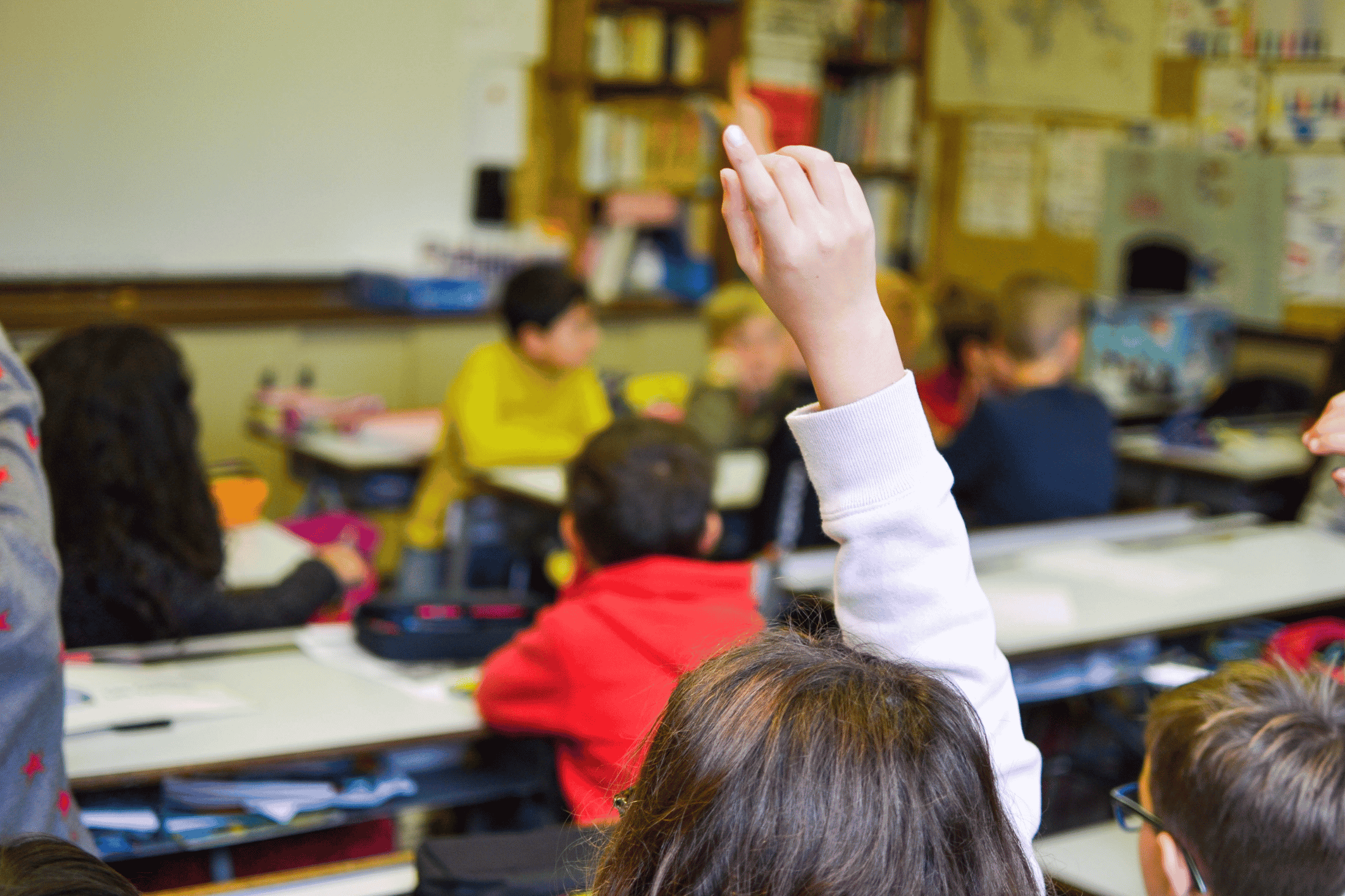 Un élève lève la main dans une classe